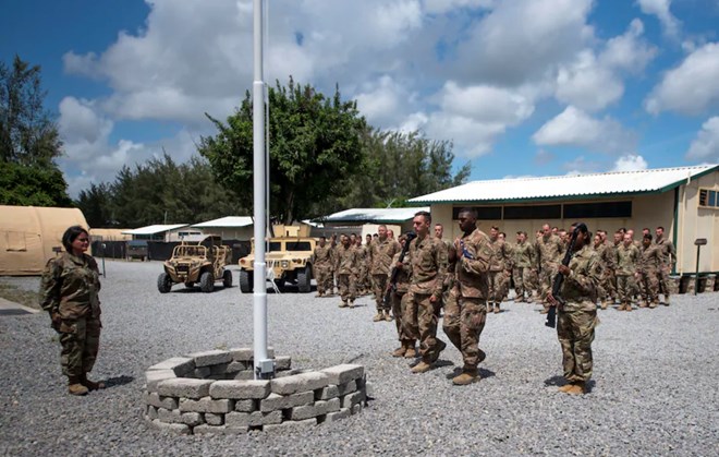 Airmen from the 475th Expeditionary Air Base Squadron conduct a flag-raising ceremony, signifying the change from tactical to enduring operations, at Camp Simba, Manda Bay, Kenya, on Aug. 26, 2019. (Staff Sgt. Lexie West/U.S. Air Force/AP)