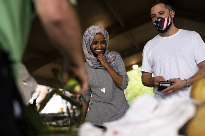 Ilhan Omar campaigns with her husband Tim Mynett at the Richfield Farmers Market on 8 August 2020 in Richfield, Minnesota(Getty)