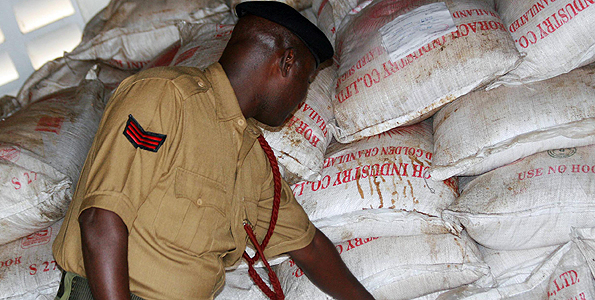 An administration police officer inspects illegal sugar imports impounded by KRA officials at the Lunga Lunga border point in 2006. Investigations show illicit trade in the commodity continues in towns and trading centres along the Somalia border. Photo/FILE 