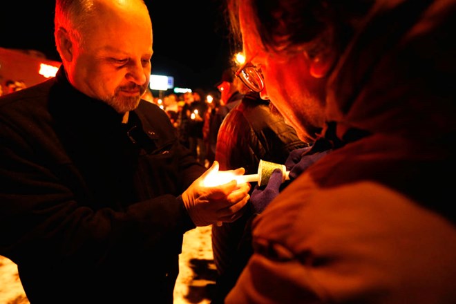 Victor Lieberman (right) lights Dr. Babil Suleiman's candle at Tuesday nights rally in support of the Juba restaurant Jesse Trelstad/ Grand Forks Herald