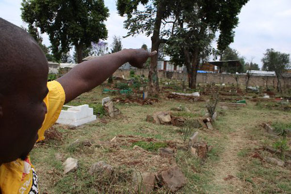 The narrator at a cemetery in Pumwani where he says most of his childhood friends are buried, having been killed in the line of crime.