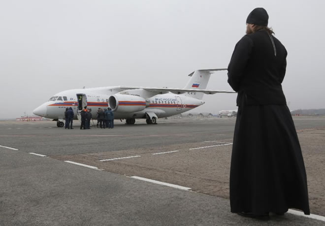 A Russian Orthodox priest looks on as the bodies of victims of the Sinai plane are flown back to St. Petersburg, on November 6, 2015 (AFP Photo/Dmitry Lovetsky)