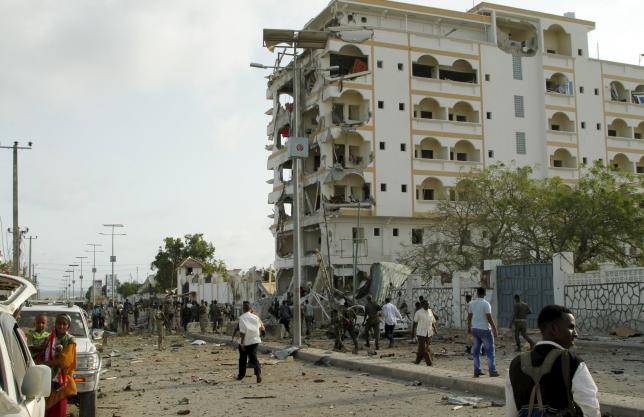 Somali government soldiers stand near the ruins of the Jazeera hotel after an attack in Somalia's capital Mogadishu, July 26, 2015.