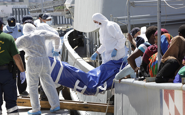 Forensic police officers disembark the body of a migrant from the Croatian vessel SB 72 Mohorovicic, at Reggio Calabria harbor, Italy. The SB 72 Mohorovicic rescued some 350 migrants and one body from a smugglers boat in the Mediterranean Sea.