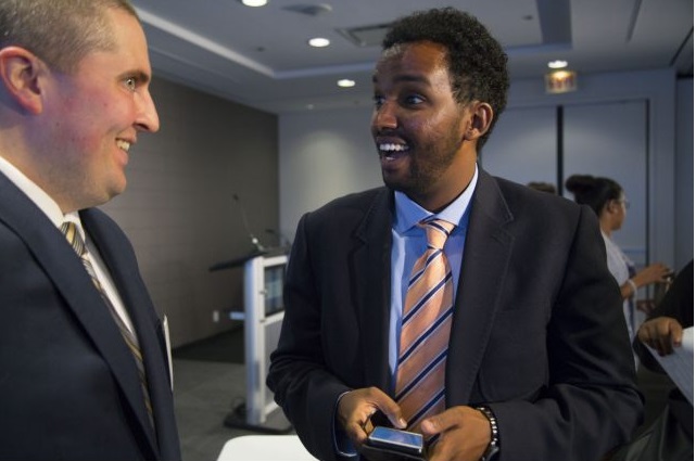 Mentor Luke Speers, left, of Accenture, talks with Zakaria Abdulle who turned his life around with help from a mentoring program sponsored by the United Way.