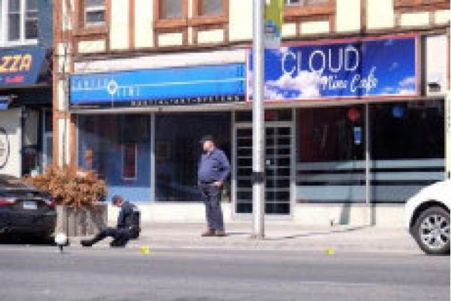 Police inspect the scene outside the Cloud Nine Cafe at 1530 Danforth Ave.on Sunday after a fatal shooting hours earlier.