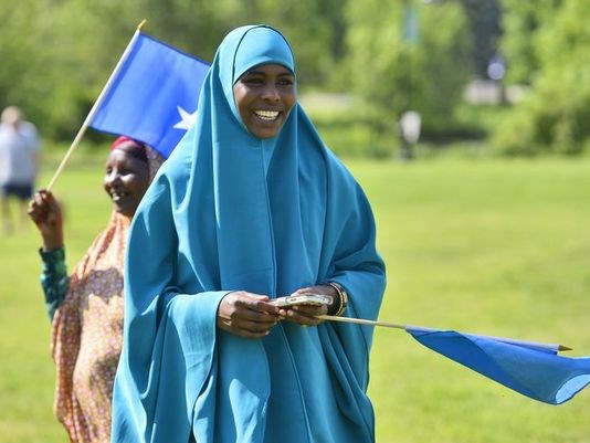 Ubah Sheikhadan, right, and Khadija Hussein carry Somali flags during Somali Independence Day events in St. Cloud in June.
