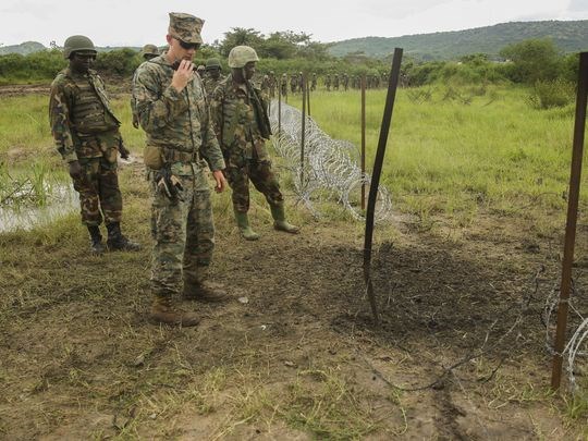 Staff Sgt. Malachi McPherson, an explosive ordnance disposal technician with Special-Purpose Marine Air-Ground Task Force Crisis Response-Africa and Ugandan soldiers observe the efficiency of their breach on a razor-wire obstacle during a training exercise at Camp Singo. (Photo: Marine Corps)