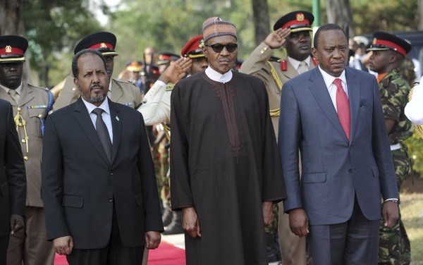 Kenya's President Uhuru Kenyatta, right, leads an interfaith memorial service honoring Kenyan soldiers killed while on peacekeeping duty in Somalia, accompanied by President Muhammadu Buhari of Nigeria, center, and Somalia's President Hassan Sheikh Mohamud, left, at a military barracks in Eldoret, Kenya Wednesday, Jan. 27, 2016. In Nigeria Buhari faces the Boko Haram extremist insurgency while Mohamud's government in Somalia relies on foreign troops including Kenya's to protect against the Islamic extremists al-Shabab. ()