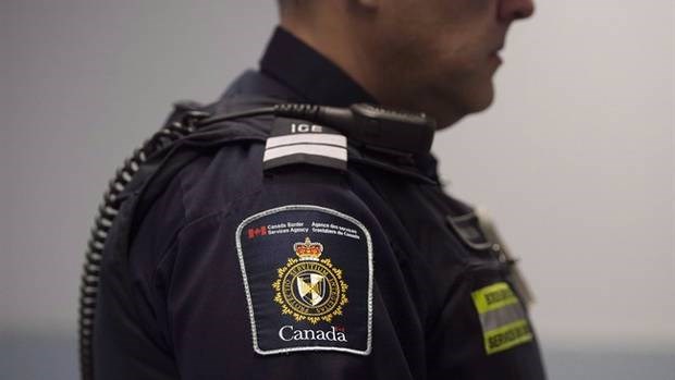 A Canadian Border Services agent stands watch at Pearson International Airport in Toronto, Ont. on Tuesday, December 8, 2015.