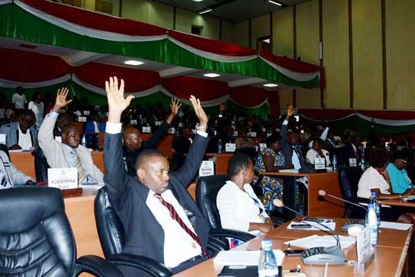 Members of Burundi's lower house of parliament raise their arms to vote on October 12, 2016 in Bujumbura to withdraw from the International Criminal Court. AFP PHOTO