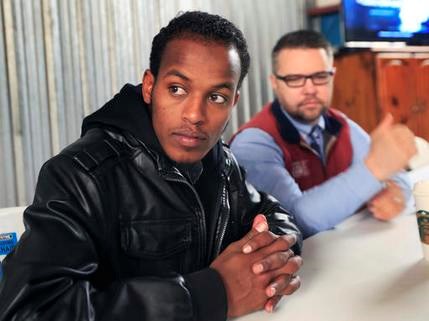 In this Friday, Feb. 3, 2017 photo, Somali refugee Mursal Naleye sits with Benjamin Anderson at the African Shop in Garden City, Kan. The doctors have become so important to the Somalis that when Naleye learned that Anderson and two physicians were going to Africa in November, he felt obligated to join them. (AP Photo/Orlin Wagner)
