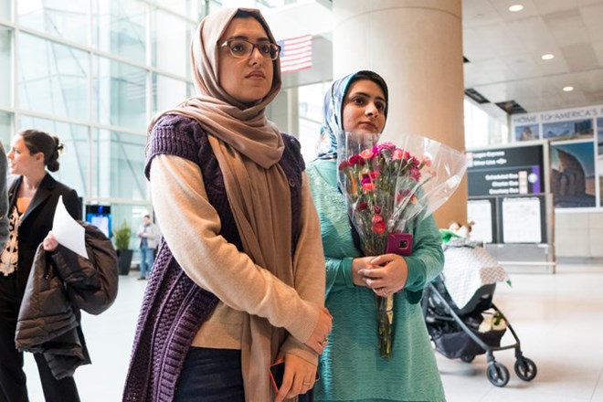 Sahar Harati, left, and Motahhare Eslami waiting for their parents to arrive at Logan Airport in Boston on Sunday.