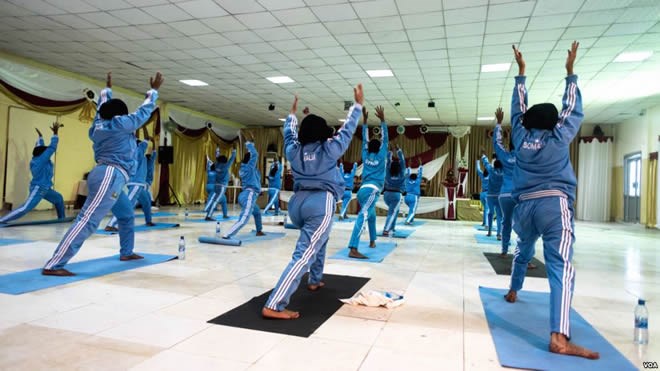 Women stretch with their arms up during a mind-body wellness program for survivors of trauma in the Somali capital of Mogadishu, Jan. 16, 2017. (J. Patinkin/VOA)