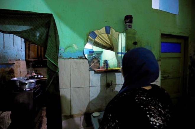 Esraa Salah, 15, looks at herself in the mirror at her home in Alwasata village of Assiut Governorate, south of Cairo, Egypt, February 8, 2018. Picture taken February 8, 2018. REUTERS/Hayam Adel