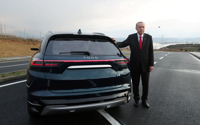 Turkish President Tayyip Erdogan poses with a prototype of the domestic electric car project in Gebze, Turkey, December 27, 2019. Presidential Press Office/Handout via REUTERS