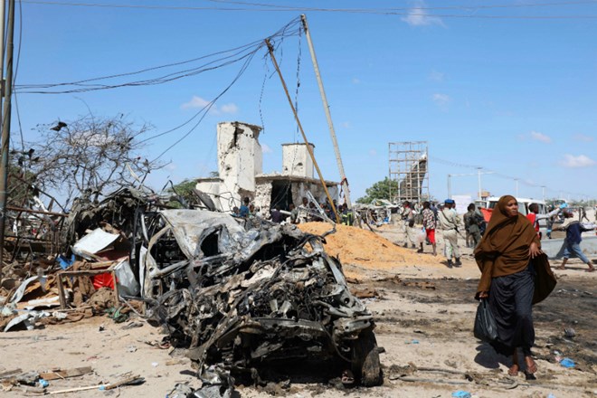 A Somali woman walks past a wreckage at the scene of a car bomb explosion at a checkpoint in Mogadishu, Somalia December 28, 2019. REUTERS/Feisal Omar