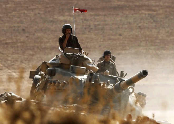 SANLIURFA, TURKEY - OCTOBER 13: (TURKEY OUT) Turkish soldiers hold their position on a tank as they watch the town of Kobani from near the Mursitpinar border crossing, on the Turkish-Syrian border in the southeastern town of Suruc in Sanliurfa province October 13, 2014. The strategic border town of Kobani has been beseiged by Islamic State militants since mid-September forcing more than 200,000 people to flee into Turkey. (Photo by Gokhan Sahin/Getty Images) (Photographer: Gokhan Sahin/Getty Images Europe)