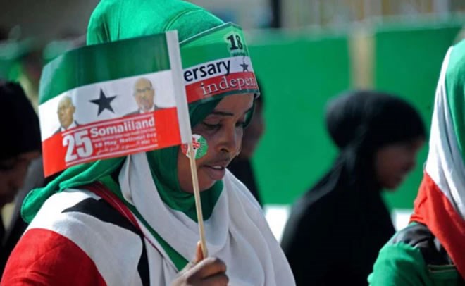 A woman waves a flag of Somaliland during an Independence Day. PHOTO | FILE | NATION MEDIA GROUP