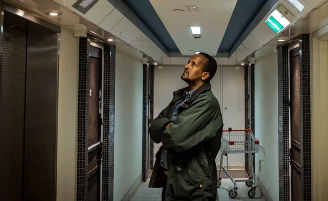 Hamdi Ali, a resident at the 141 Nicholson Street flats, waits for the elevator on the sixth floor. Photograph: Christopher Hopkins/The Guardian