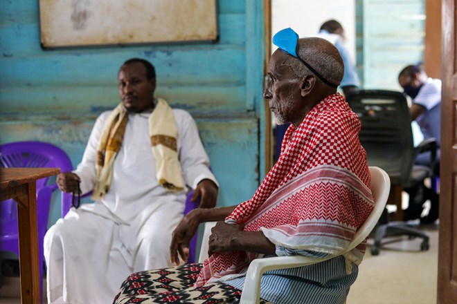 Haret Abdirahman sits with his youngest son during a consultation at MSF's mental health clinic. Haret's eldest son took his own life in August 2020./MSF