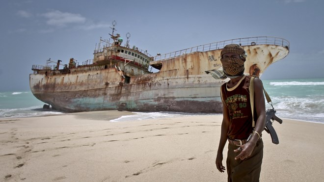A masked Somali pirate stands near a Taiwanese fishing vessel that washed up in 2012 after the pirates were paid a ransom and released the crew. The image appears on the cover of Michael Scott Moore's new book The Desert and the Sea.
Farah Abdi Warsameh/AP