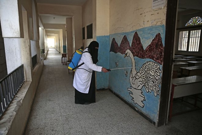 A worker disinfects a school as a preventive measure against the spread of the new coronavirus before students taking a final-term school exam at a public school in Sanaa, Yemen, Saturday, Aug. 29, 2020. (AP Photo/Hani Mohammed)