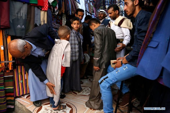 People shop for new clothes ahead of Eid al-Adha at a market in Sanaa, Yemen, July 18, 2021. (Photo by Mohammed Mohammed/Xinhua)