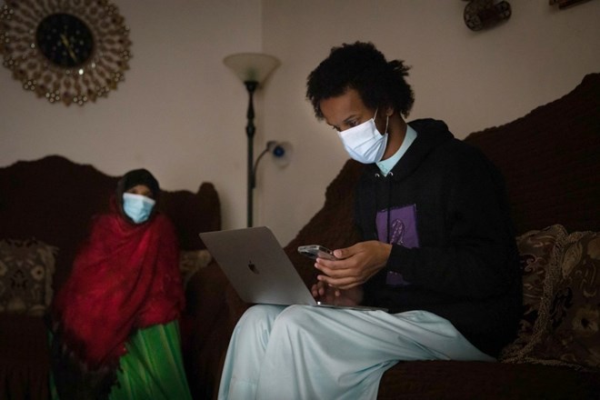 Ahmad Mahmuod helps his aunt check in with the status of the Coronavirus Relief Grant for her small business.(Heloisa De Oliveira / For The San Diego Union-Tribune)