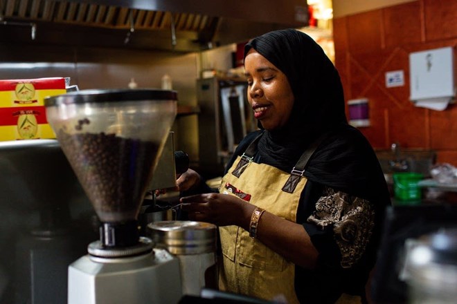 Karima Omer, owner of Sabrina's Cafe & Deli in St. Paul, makes coffee for a customer.Nicole Neri for MPR News