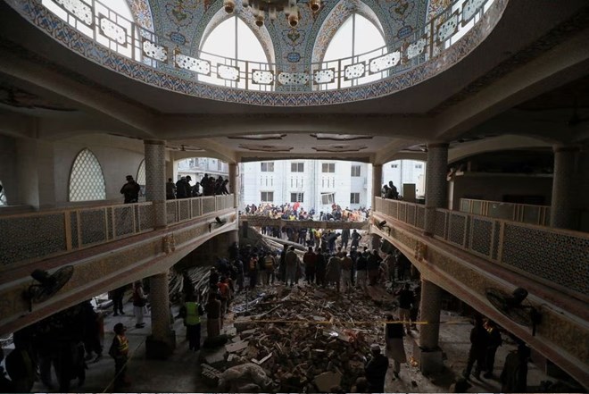 People and rescue workers gather to look for survivors under a collapsed roof, after a suicide blast in a mosque in Peshawar, Pakistan January 30, 2023. REUTERS/Fayaz Aziz