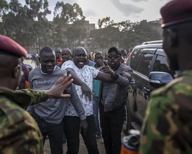 People argue with security forces trying to keep order after a few ballot boxes were discovered with their seals broken, at a tallying center in the Mathare area of Nairobi, Kenya Wednesday, Aug. 10, 2022. Kenyans are waiting for the results of a close presidential election in which the turnout was lower than usual. BEN CURTIS / AP PHOTO