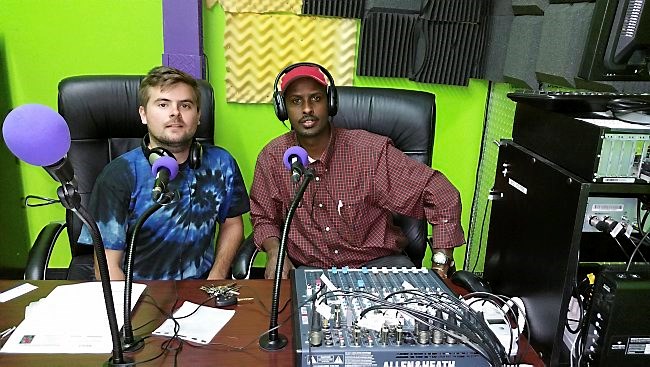 Will Floyd, left, technical director for the Prometheus Radio Project, and KALY 101.7 FM Executive Director Mahamed Cali are shown in the broadcast booth Sept. 24, the day the Somali community radio station went on the air. (Photo by Layla Deeq, courtesy Mahamed Cali)