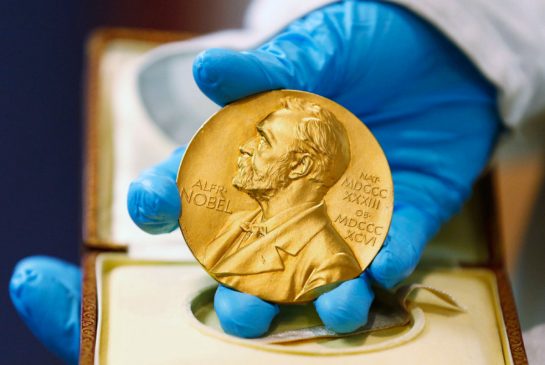 A national libray employee shows the gold Nobel Prize medal.