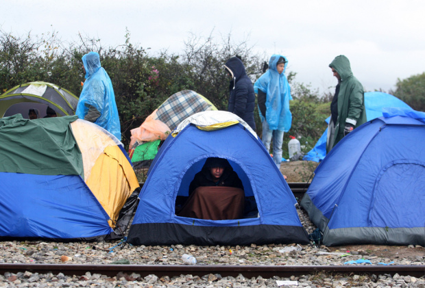 Migrants and refugees wait at a makeshift camp to cross the Greek-Macedonian border near Idomeni on November 27, 2015.