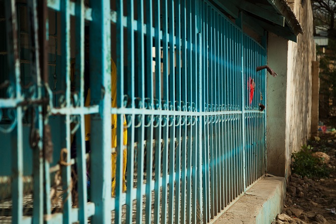 A female patient reaches out through the bars at the entrance of the Hargeisa Group Hospital's mental health ward. This ward is one of four under-resourced and dilapidated public mental health facilities across Somaliland. In response to demand, expensive and under-regulated private centres are springing up across the capital Hargeisa. [Zoe Flood/Al Jazeera]