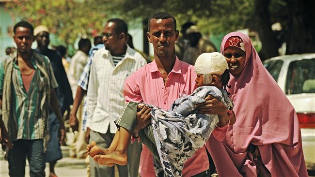 A man carries an injured Somali child to hospital on September 22, 2015 following a car bomb attack on September 21. (AFP Photo)