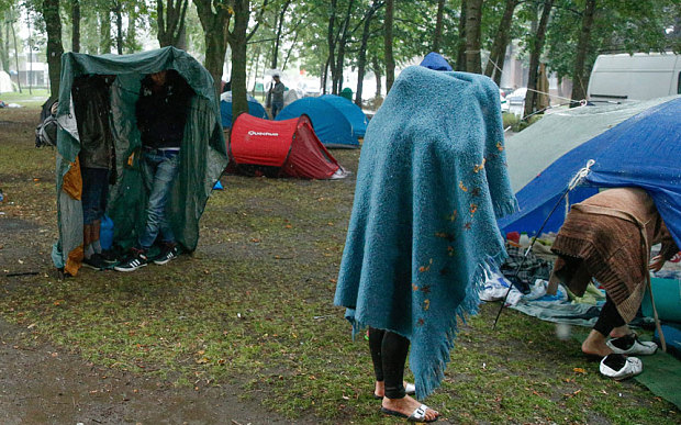 Refugees wait in a park in front of the office for foreigners in Brussels, Belgium