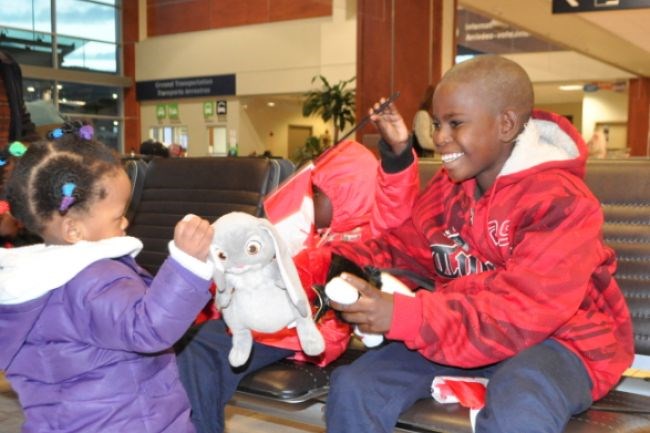 Mohamed, the second son, relaxed by playing with interpreter Lul Omar's daughter. All of the Somali children received toy bears at the airport.