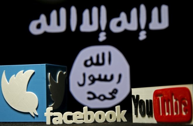 3D plastic representations of the Twitter, Facebook and YouTube logos are seen in front of a displayed Isis flagREUTERS