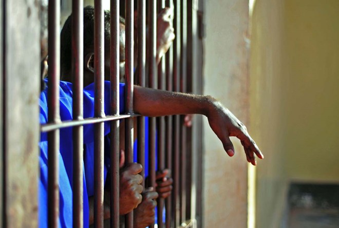 Prisoners stand behind bars, at the prison in Garowe, Puntland state, in northeastern Somalia, on December 14, 2016. The prison facilitates the rehabilitation of convicted Somali pirates and suspected Al-Shabaab jihadists. (MOHAMED ABDIWAHAB/AFP/Getty Images)