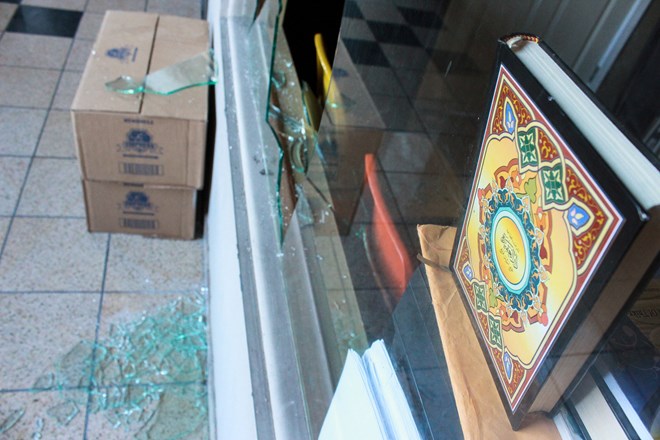 A copy of the Quran is shown above the shattered glass above one of the broken windows at the south Minneapolis mosque.