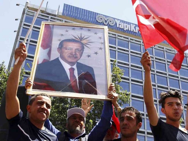 Supporters of Turkish President Tayyip Erdogan lift up his portrait as they celebrate with flags in Ankara, Turkey, July 16, 2016. /REUTERS