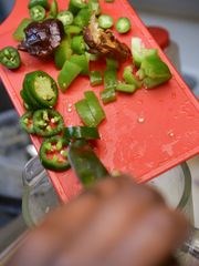 Faisa Omar adds chopped dates, green peppers and jalapenos to a blender to make bis-baas, a hot sauce, on Tuesday, June 7. (Photo: Kimm Anderson, kanderson@stcloudtimes.com)