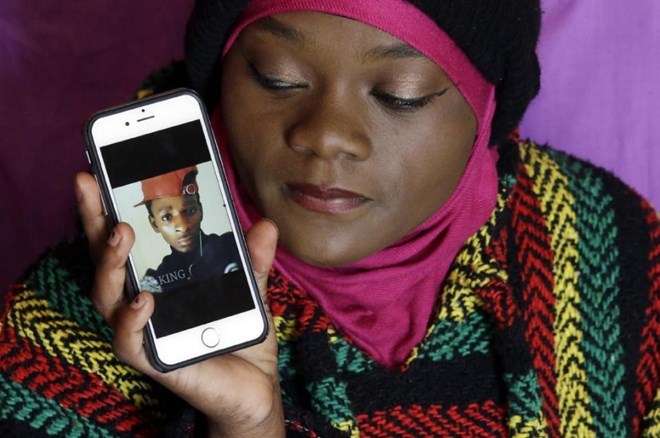 Abdi Mohamed's cousin Muslima Weledi holds a photograph of him during a interview. AP