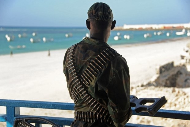 A Somali soldier looks at the Lido beach from the terrace of the Lido seafood restaurant on 22 January 2016 following an overnight attack (AFP)