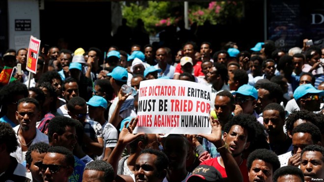 FILE - Eritrean refugees hold placards during a rally in support of a recent U.N. report that accused Eritrean leaders of committing crimes against humanity, outside the E.U. offices in Ramat Gan, Israel, June 21, 2016.