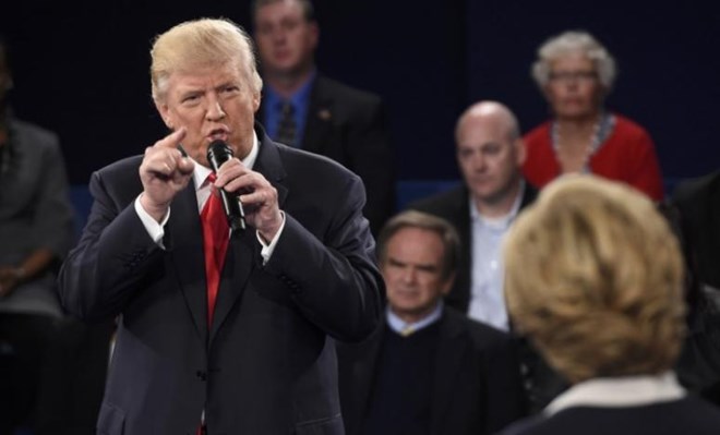 Republican U.S. presidential nominee Donald Trump speaks as Democratic U.S. presidential nominee Hillary Clinton (R) listens during their presidential town hall debate at Washington University in St. Louis, Missouri, U.S., October 9, 2016. REUTERS/Saul Loeb/Pool