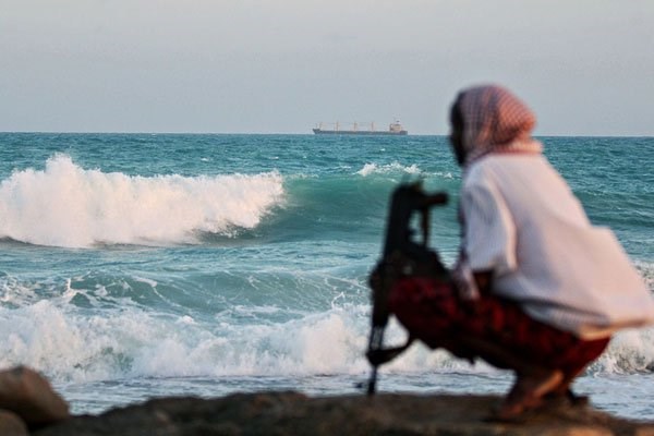 A photo taken on January 4, 2010 shows an armed Somali pirate keeping vigil on the coastline near Hobyo, northeastern Somalia. AFP | MOHAMED DAHIR