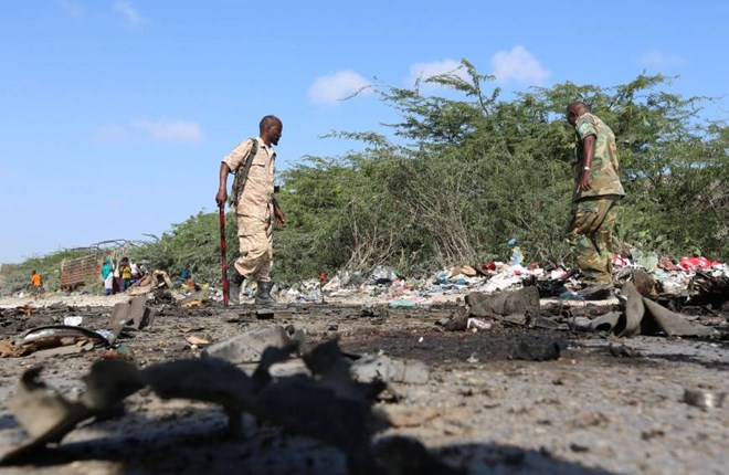 Somali soldiers inspect the scene of a suicide car bomb attack by al Shabaab in Somalia's capital Mogadishu on Sunday. | REUTERS